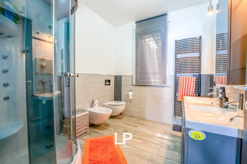 Glass shower stall, double sink, bidet, radiator, carpet, towel rack