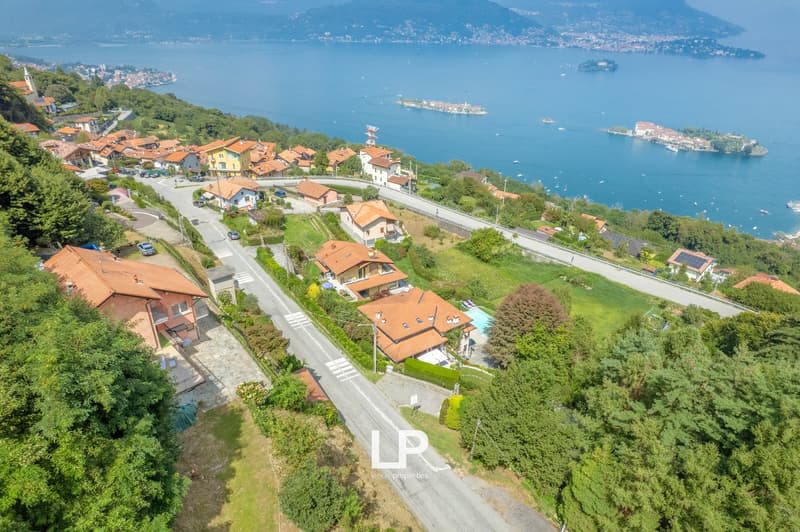 Multiple houses with swimming pool, road, mountain, lake, trees