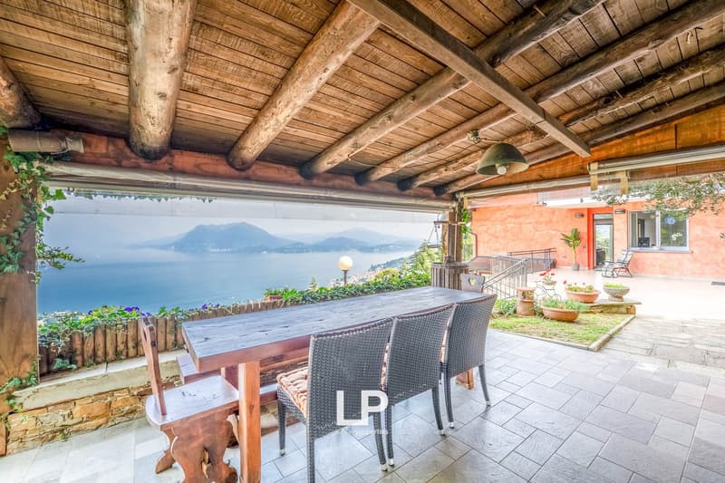 wooden dining table and chairs, brick patio, wooden ceiling, ocean view, flower pots, lamps