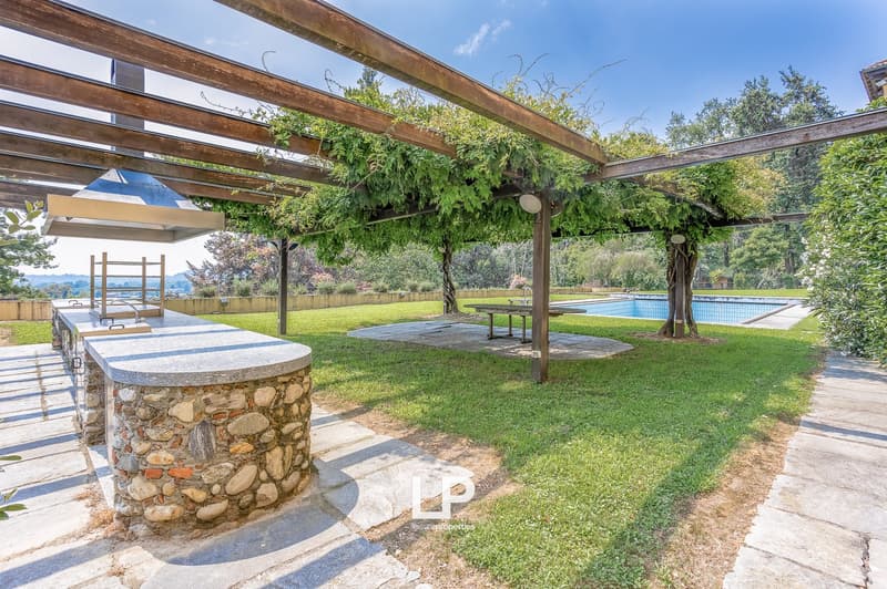 Garden with pergola, wooden table, grill, swimming pool, lawn, trees, hills