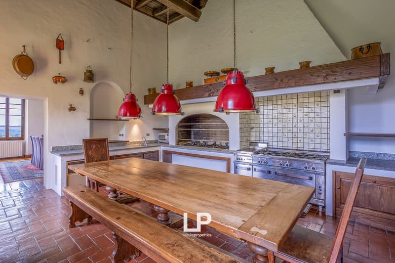 wooden dining table, benches, kitchen with oven and gas stove, red lamps