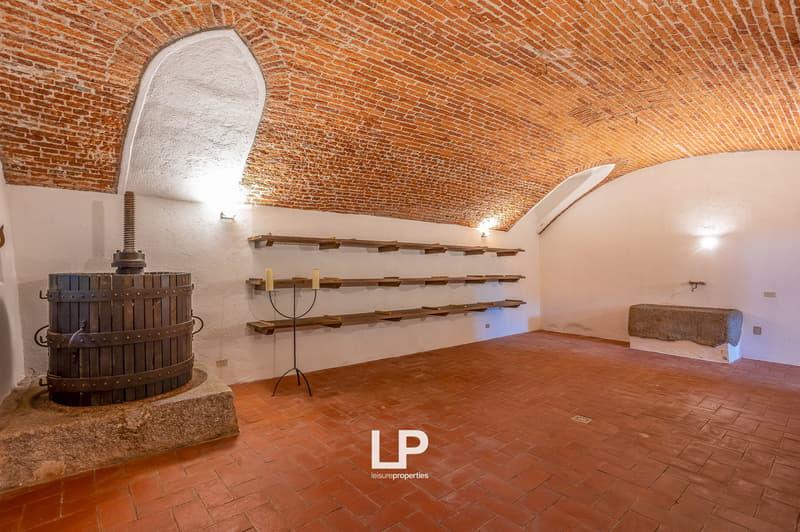 a cellar with barrel, brick arch ceiling, shelves, tiled floor