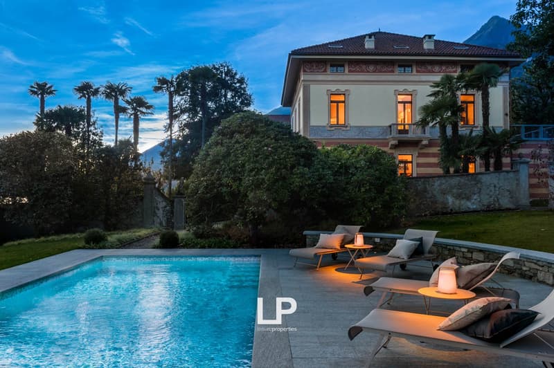 large house, surrounded by trees, swimming pool, loungers, mountains in the background