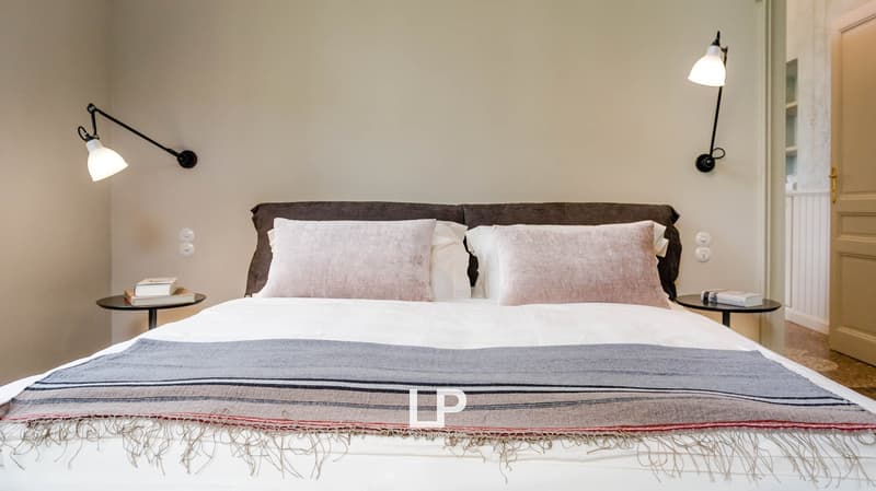 king size bed, white bedding, pink pillows, bedside tables, lamps, book on bedside table