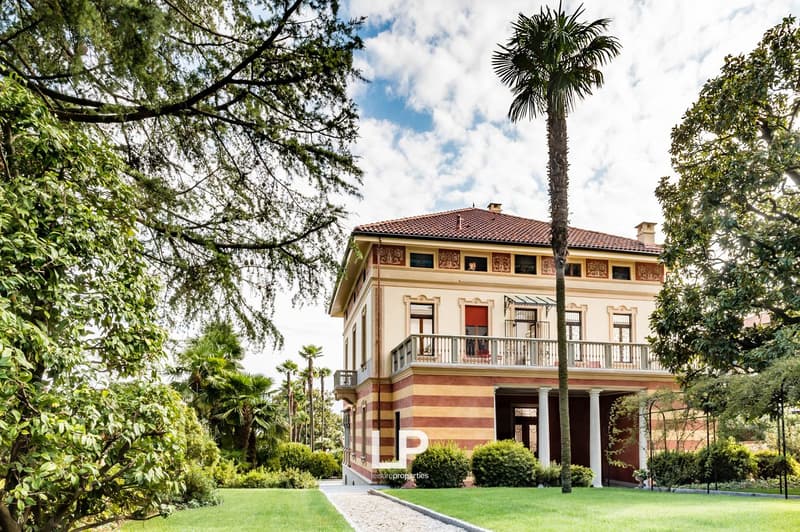 2 story house, striped walls, tiled roof, palm tree, balcony, garden