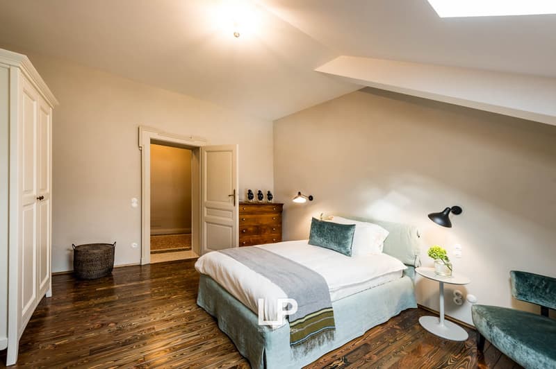 Master bedroom: bed, white walls, wooden floors, closet, nightstand, side table, lamps