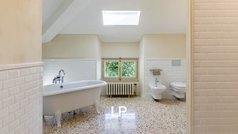 Modern bathroom, white tiles, bathtub, toilet, bidet, skylight, radiator, windows