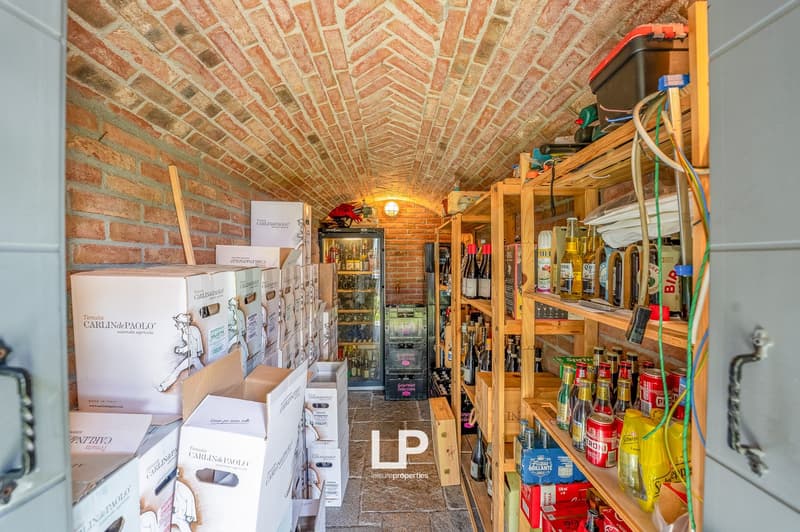Room: brick walls, wooden shelves, bottles of wine, storage boxes, storage boxes of wine, glass cabinet