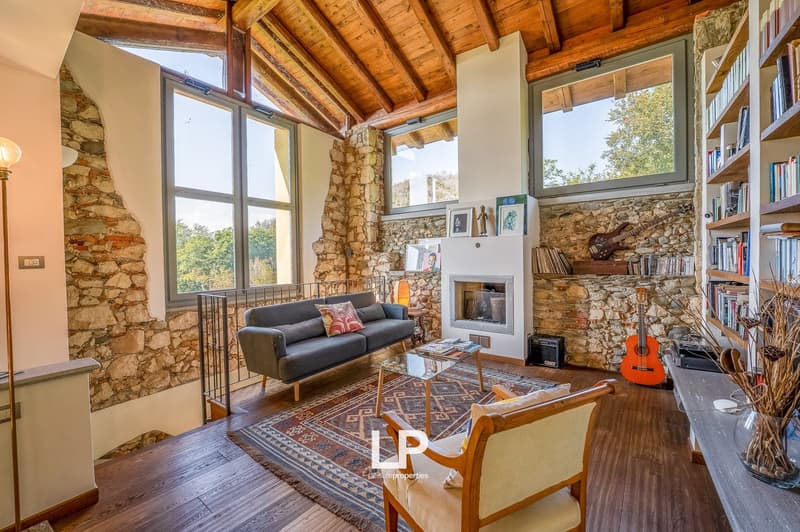 wooden ceiling, stone walls, fireplace, rug, couch, chair, coffee table, shelves, guitars, books