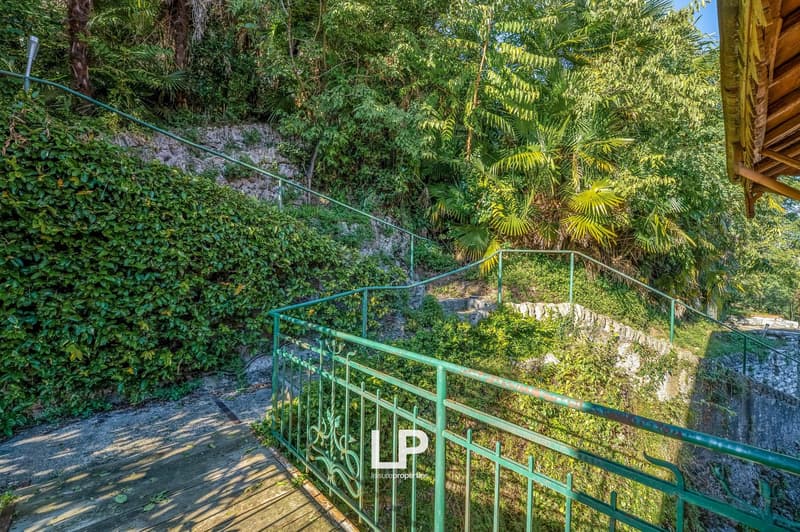 A stone walkway with metal railings on a steep slope