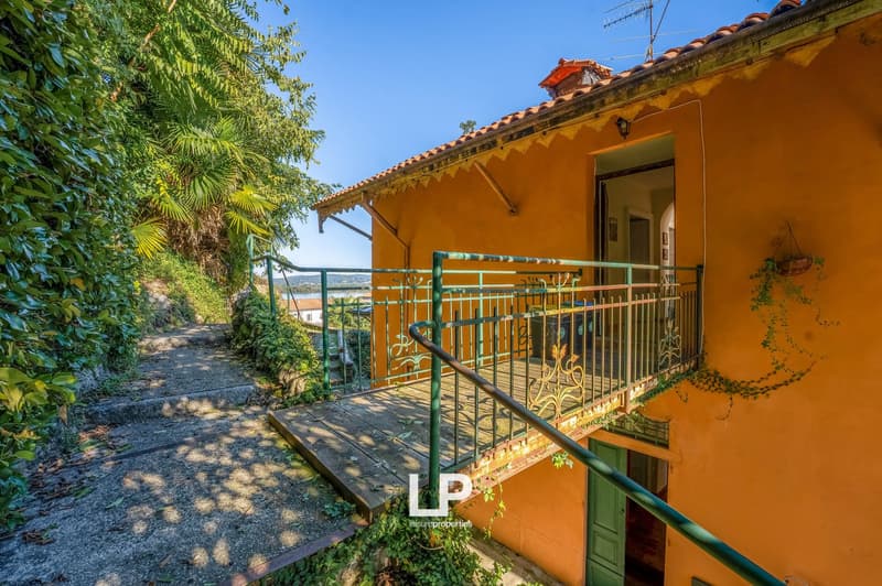 orange walls, red roof, wooden balcony, garden, concrete path
