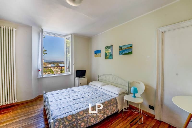 bed, pillows, chair, table, monitor, night table, paintings, balcony, window, heating