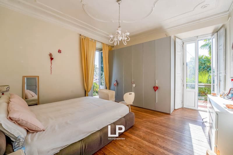 double bed, wooden floor, large windows, yellow curtains, gray wardrobe, mirror, chair, chandelier