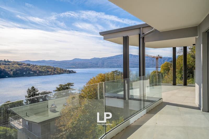 glass railing, view of the lake, mountains in the background, trees