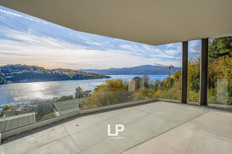 modern terrace, floor to ceiling glass walls, overlooking body of water, mountains, trees