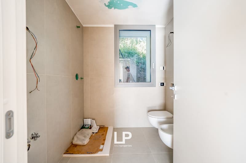 Bathroom with shower area, sink, toilet, tiles, window