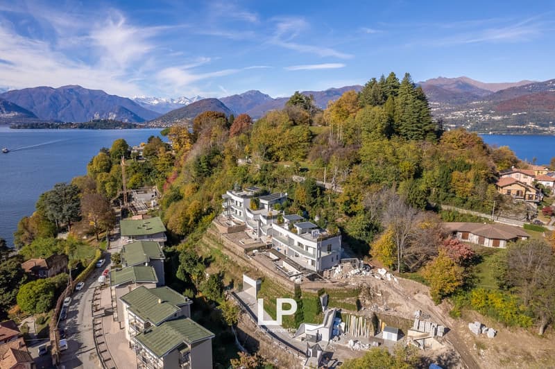 Multiple buildings, green roofs, construction site, lake, mountains in the background