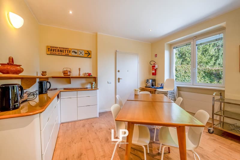 Dining area, wooden table and white chairs, white cabinets, kitchen utensils, electric kettle, small coffee machine