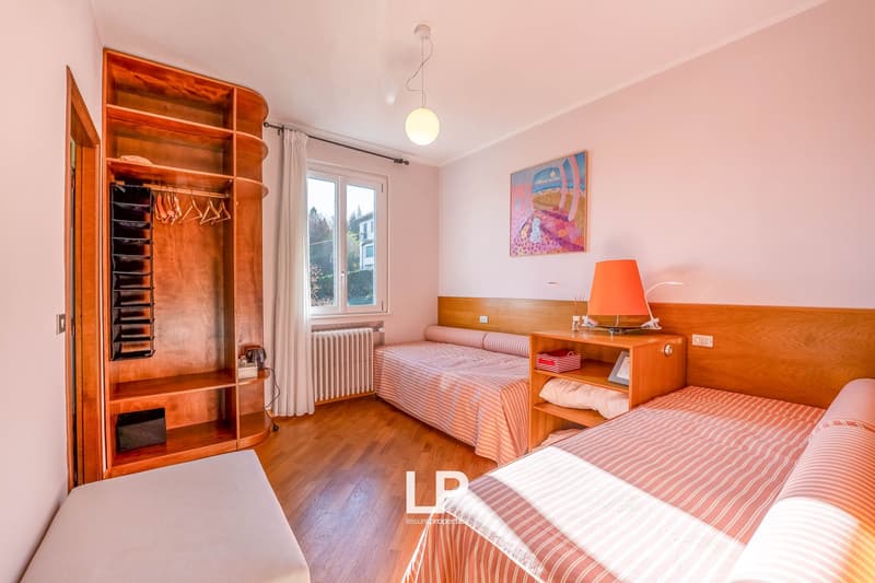 Wooden floors, wooden bed, bed, radiator, window, painting, wooden shelf, cabinet, hanging clothes