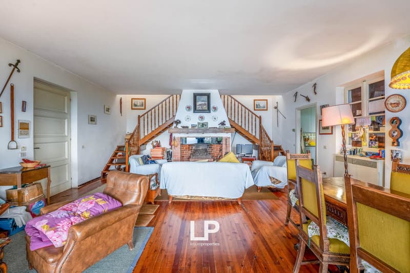 a cozy interior, wooden floors, a fireplace, a dining table, chairs, and a couch, a window, decorations on the wall