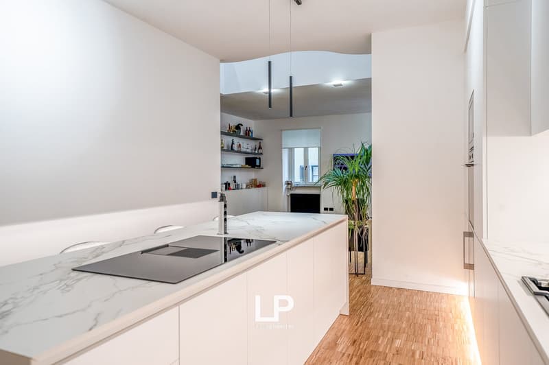 modern kitchen with island, granite countertops, stainless steel appliances, wooden flooring, open to living area, large windows