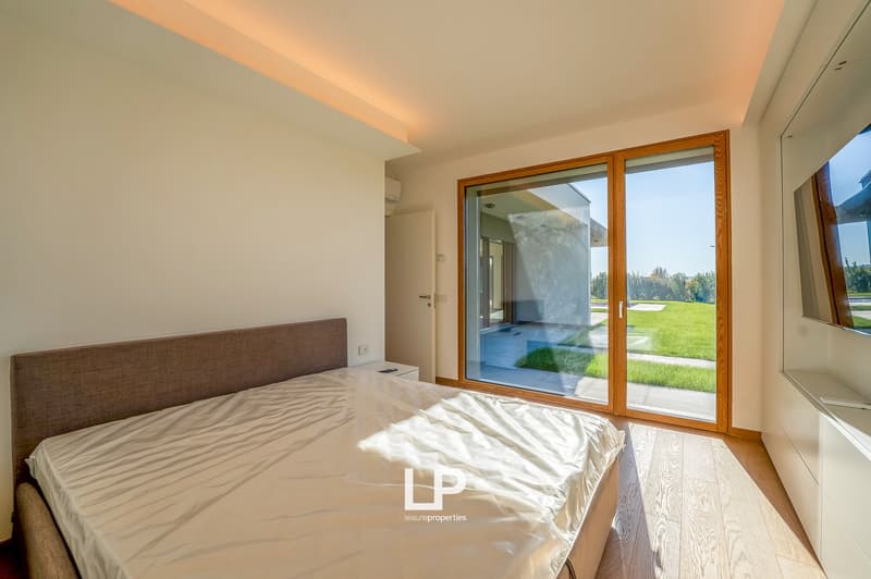 master bedroom with a bed, bedside tables, sliding glass door leading to a balcony, wardrobe, air conditioner