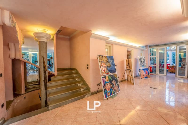 tiled floor, pink wall, staircase, pillar, paintings, open glass doors