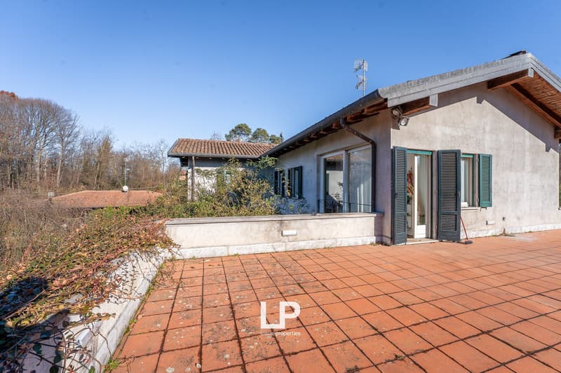 Concrete house, red roof tiles, closed windows, small terrace, concrete patio