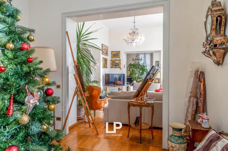wooden floor, large windows, Christmas tree, chandelier, sofa, TV, plant, vintage items