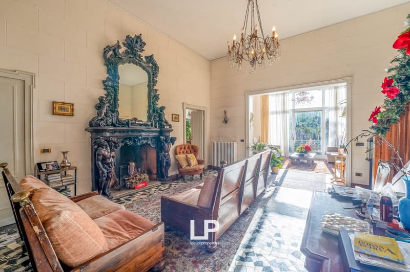 Fireplace, chandelier, wooden furniture, floral decor, tiles on the floor, table, books, and vases