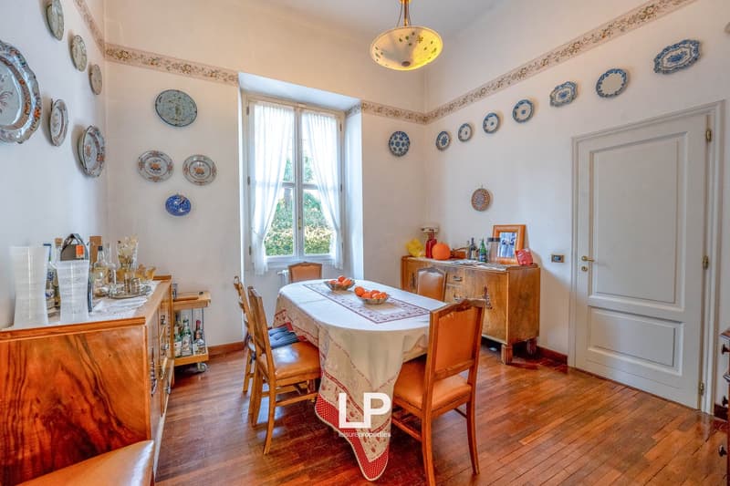 Wooden floor, wooden chair and desk, dinner table, window with curtains, plates on wall