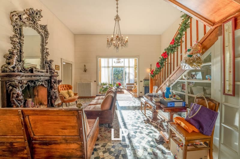 Fireplace, wooden furniture, chandelier, decorative mirror, wooden desk, couch, wooden chair, staircase, decorative garlands