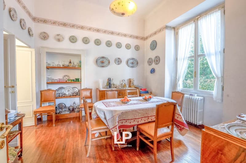 dining room, large window, wooden floor, dining table, chairs, white curtains, decorative plates on wall, shelves, wooden cabinet