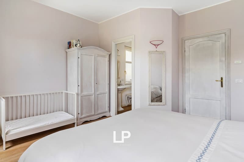 Double bed, wardrobe, crib, mirror, doorway, bathroom glimpse