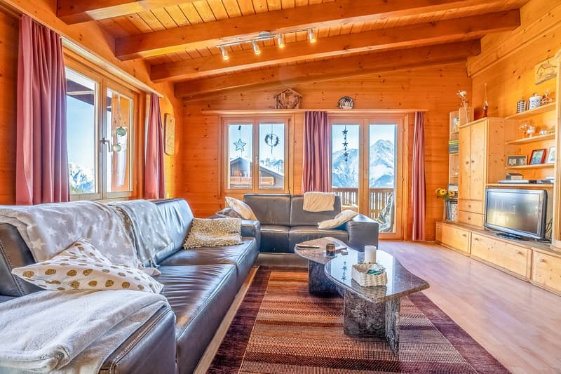 modern furnished living room with wooden ceiling, couch, coffee table, TV, and big window