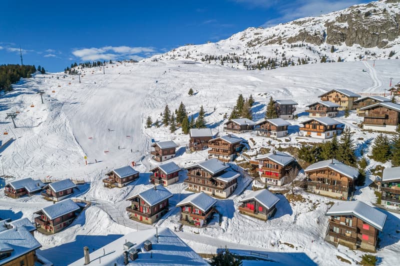 Swiss style houses on a mountain with snow
