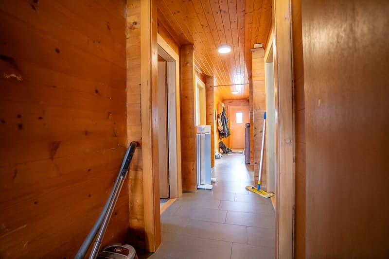 wooden walls, tiled floor, open doors, broom and dustpan
