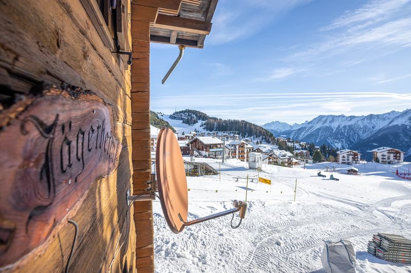 wooden exterior, large window, outdoor dish, snowy mountainous area
