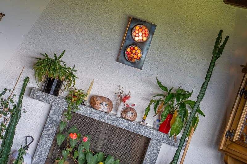 Stone fireplace, decorative plants, and cat statues