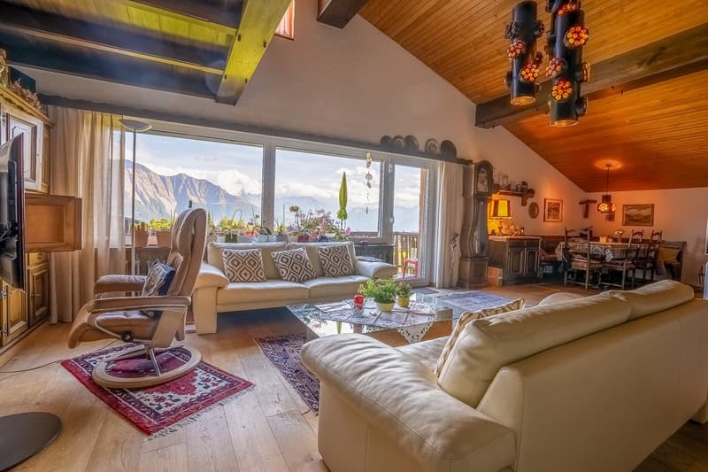 2 sofas, coffee table, large windows, wooden floor, mounted TV, dining table, view of mountains