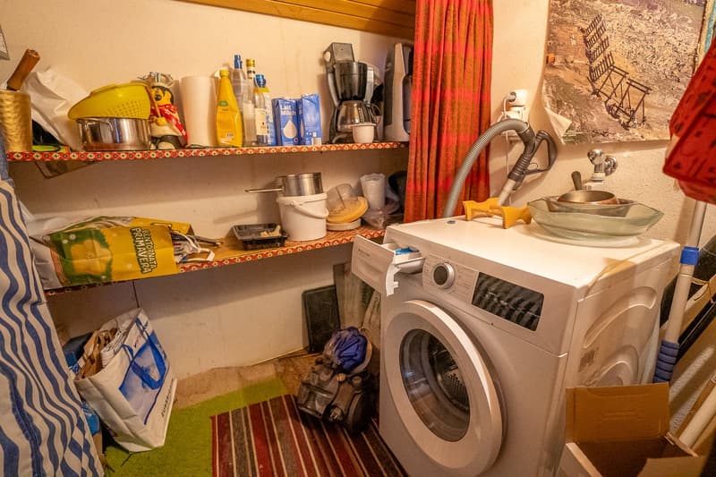 laundry area with shelves, washing machine, vacuum cleaner, bags, cleaning products