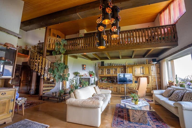 spacious living room, white leather sofas, wooden coffee table, fireplace, TV, wooden cabinet, staircase, wooden floor, hanging decorative lamps, chandelier