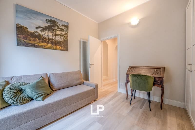 Sofa, wooden desk, wall art, floor lamp, wooden floor, closed door