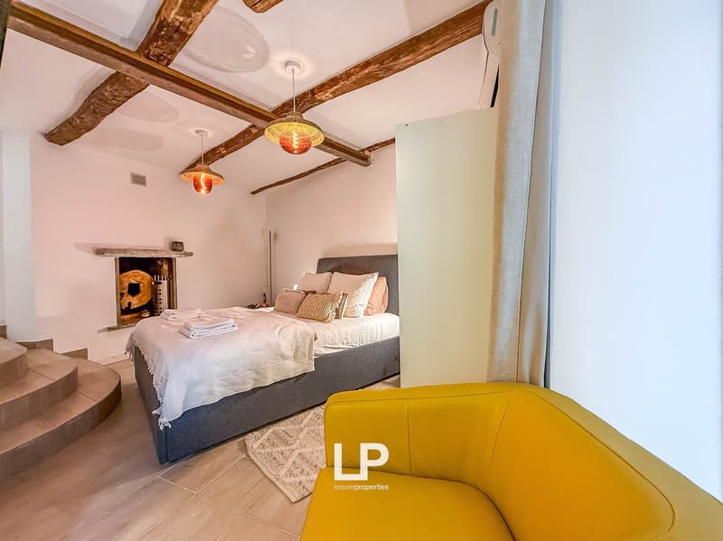 Bedroom with bed, fireplace, steps, wooden ceiling