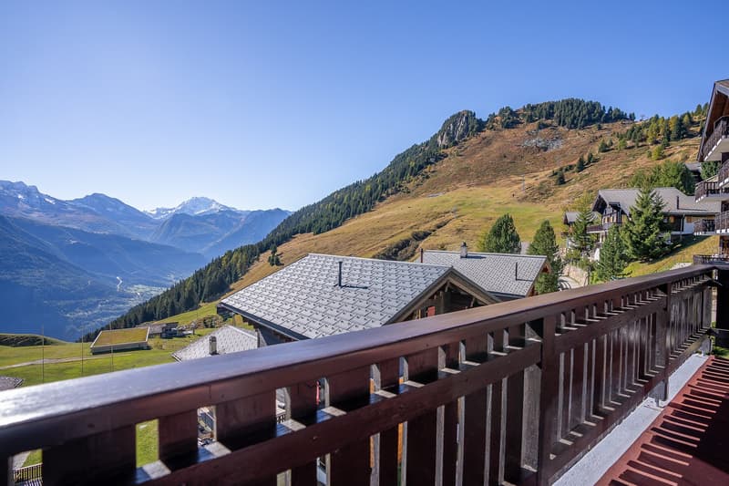 multiple chalets in the mountains with balcony, view of valley and mountains