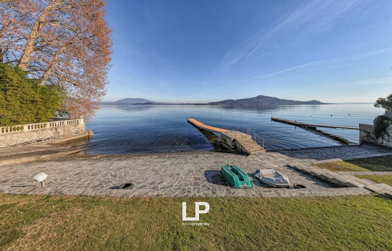 Waterfront garden with piers, boats, and a view of the lake and mountains
