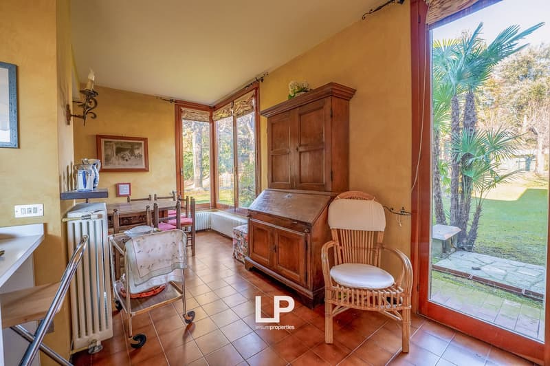 dining room with table and chairs, wooden cabinet, wicker chair, window, door, radiator, tiled floor, outdoor view