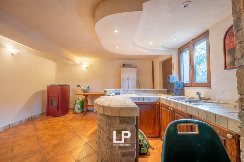 modern kitchen with a breakfast bar, wooden cabinets, tiled floor, a refrigerator, a sink, a faucet, a window with wooden frames
