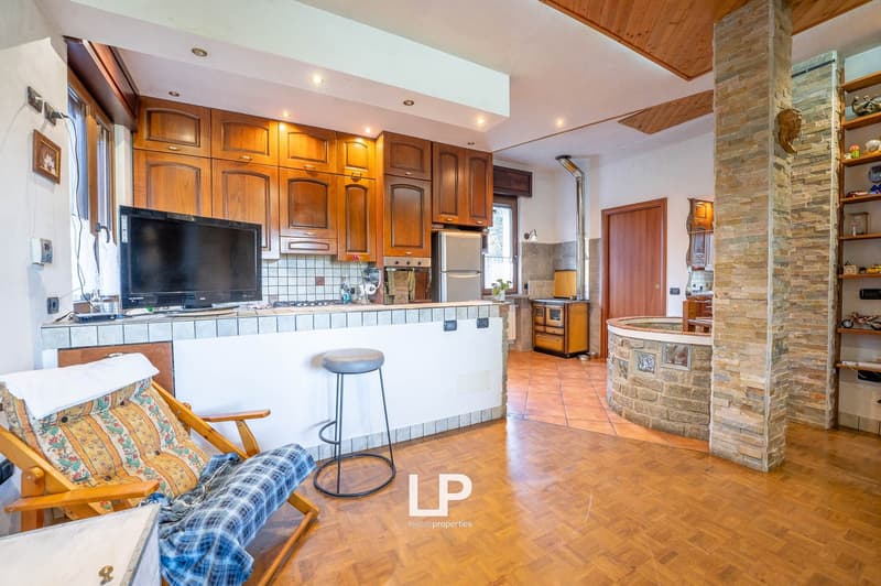 hardwood floor, tiled counter, kitchen island, wall cabinets, fridge, oven, television, bar stool, wooden chair