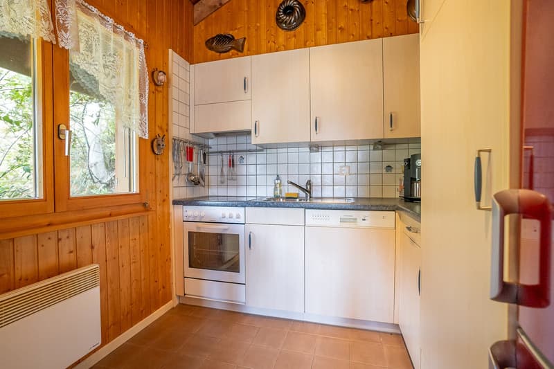 kitchen with wooden walls, white cabinets, gas stove, oven, dishwasher, sink, appliances